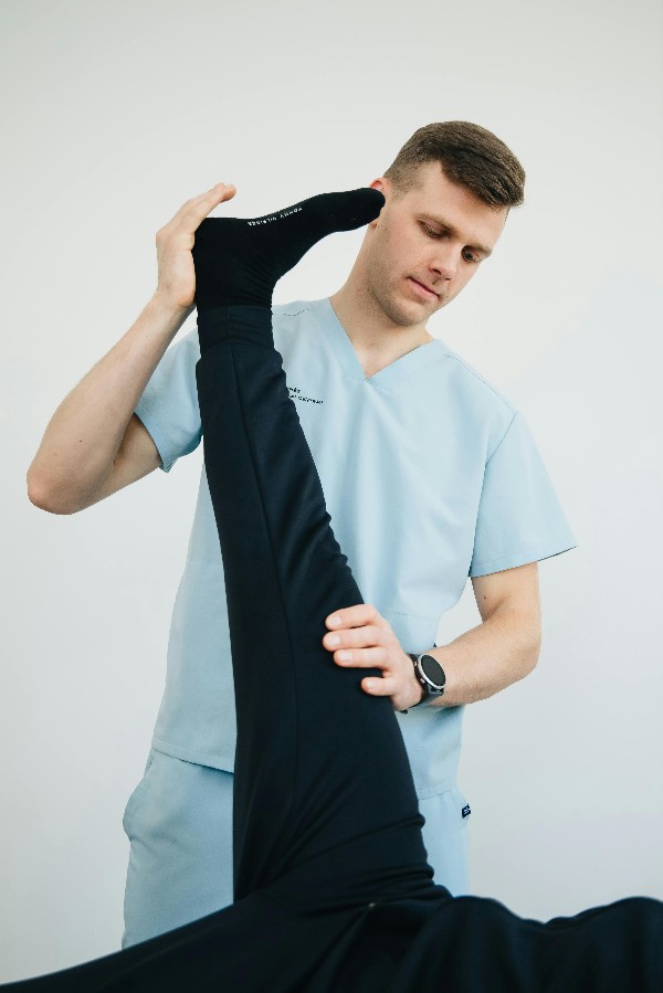 Physiotherapist performing a leg stretch assessment