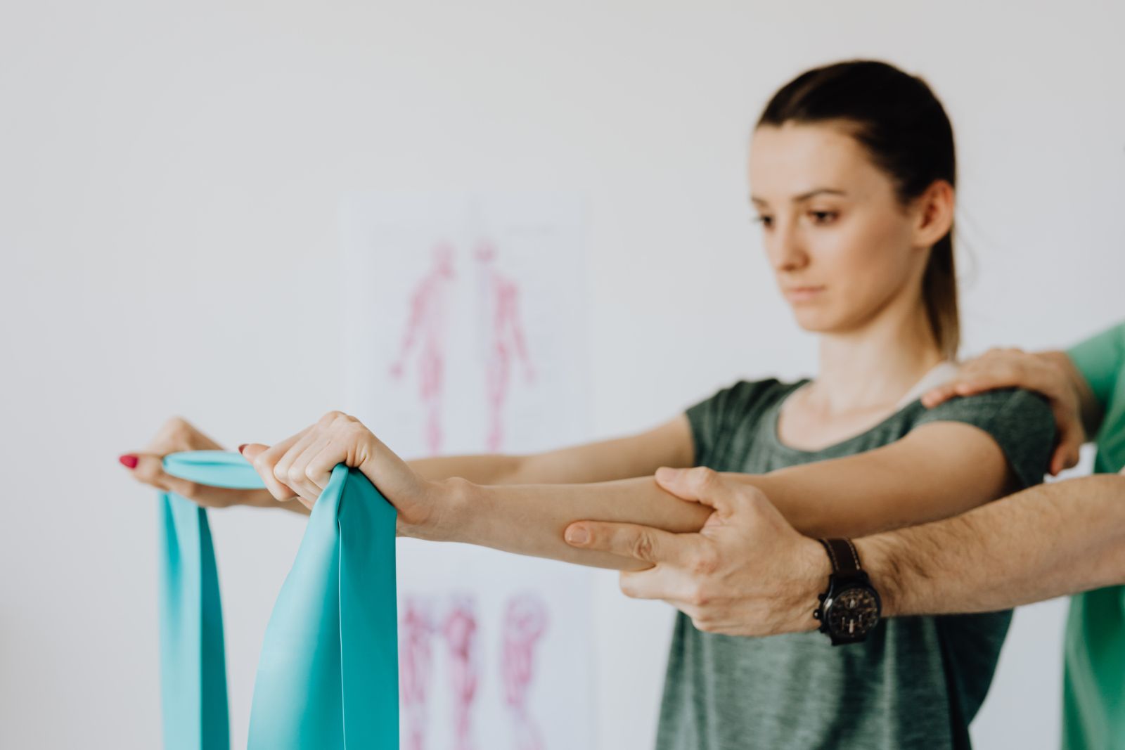 Physiotherapist guiding a patient through a shoulder exercise with a resistance band