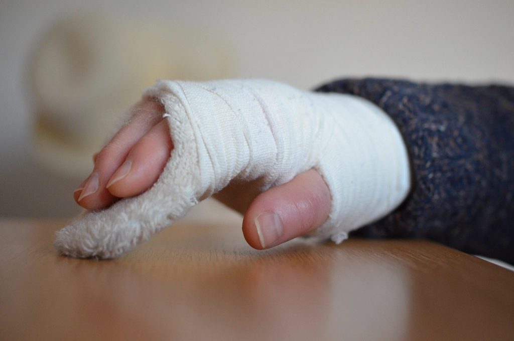 A bandaged hand and wrist resting on a table after surgery