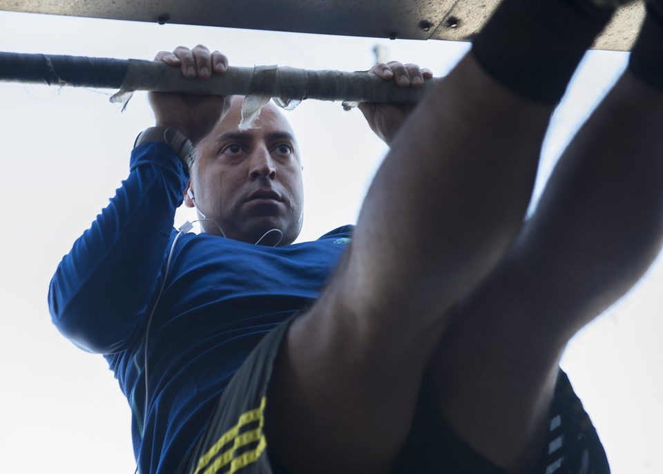 A man pulling himself up to a bar during a pull-up
