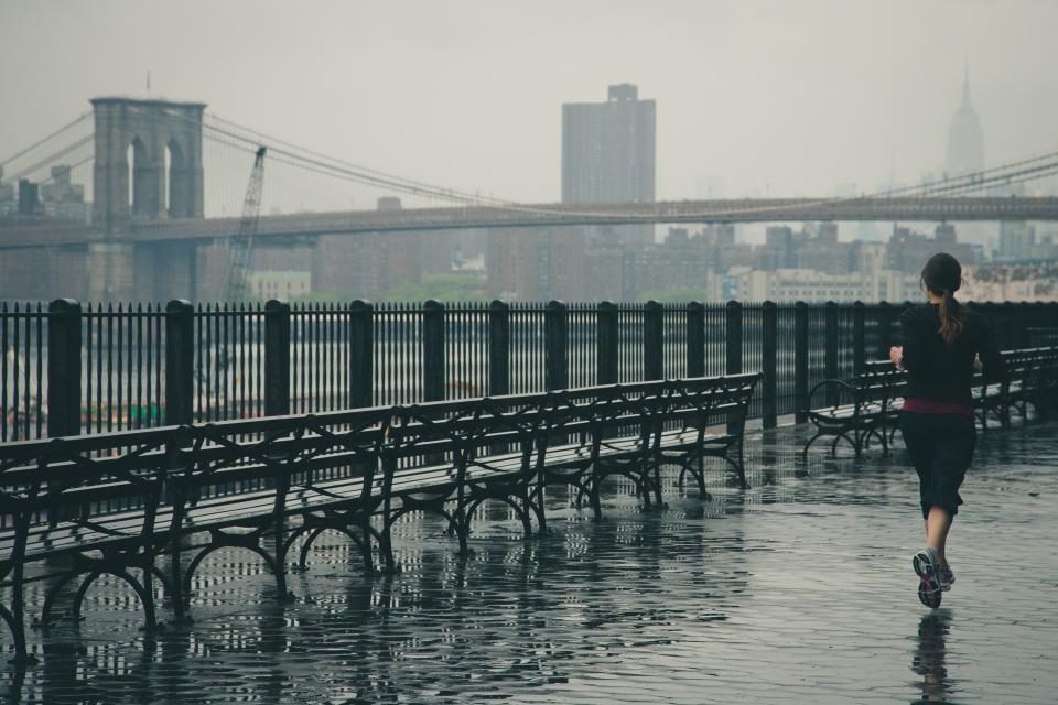 A lone runner on a boardwalk beside a river