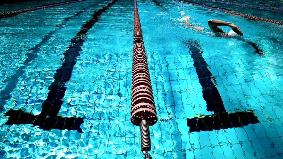 Lane ropes across a swimming pool with a swimmer mid-length